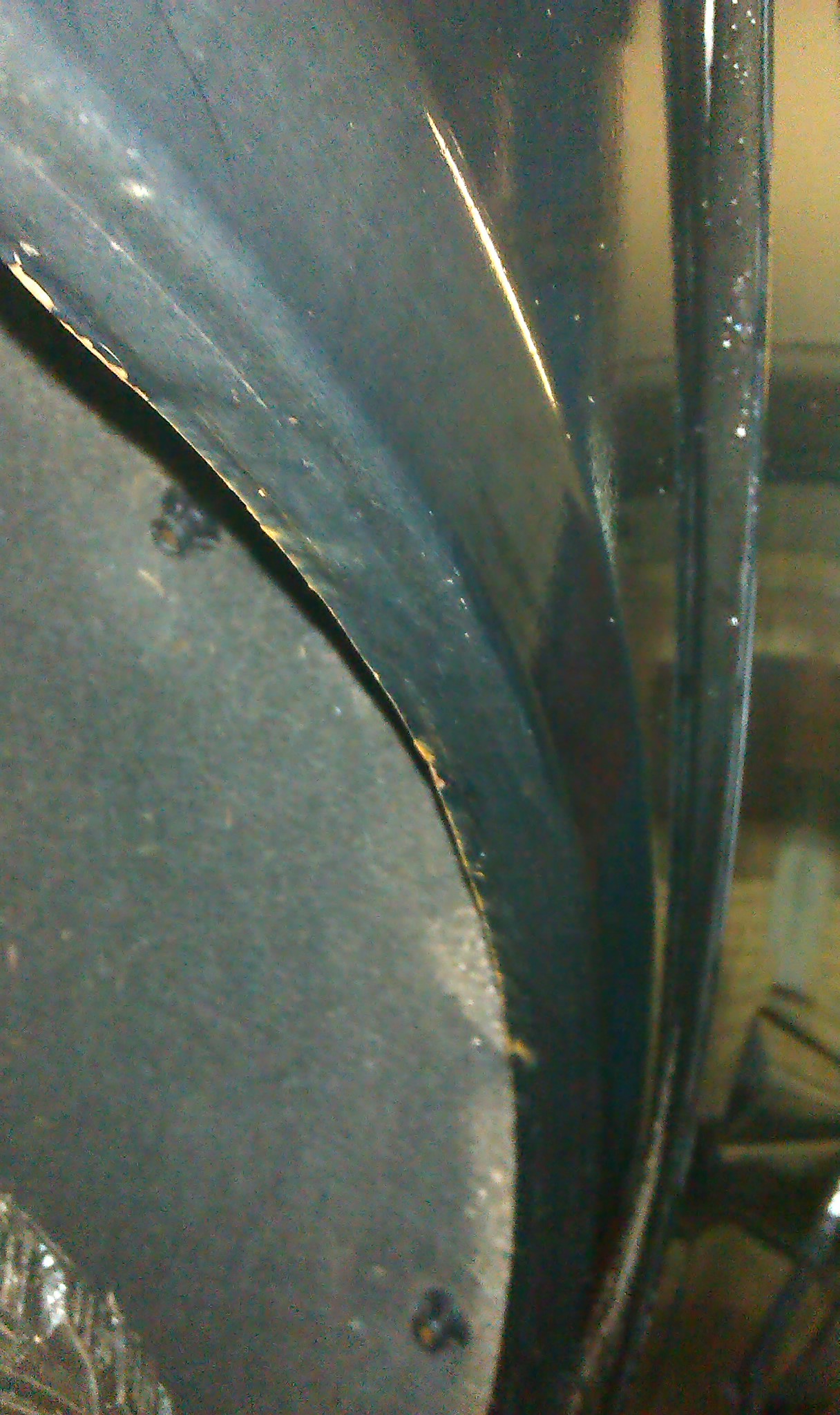 Колесная арка автомобиля, пострадавшая от гравия и песка, летящего из-под колес
